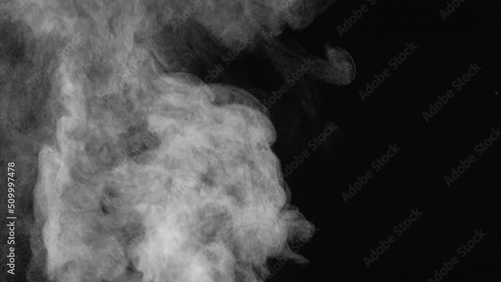 Water vapor. White jet of steam ascending and floats in air on black