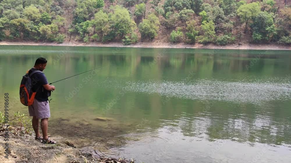 Man fishing in lake in Bhimtal Man fishing in lake in Bhimtal
