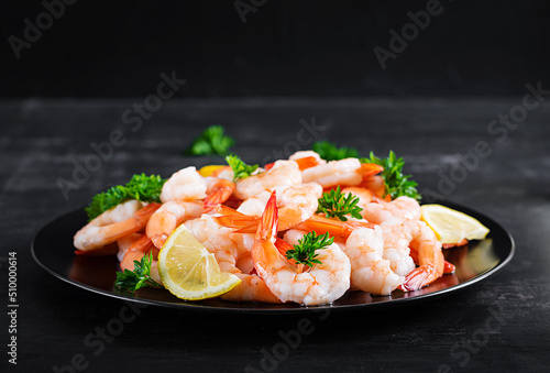 Shrimps, prawns on black plate. Boiled shrimps, prawns. Seafood.