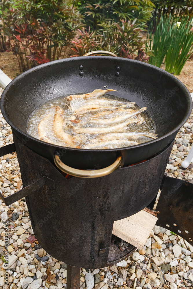 Small crispy fish are fried in oil. Roasting capelin in a pan on fire. Small fish fry in a pan. Shallow depth of field Small crispy fish are fried in oil. Roasting capelin in a pan on fire. Small fish fry in a pan. Shallow depth of field
