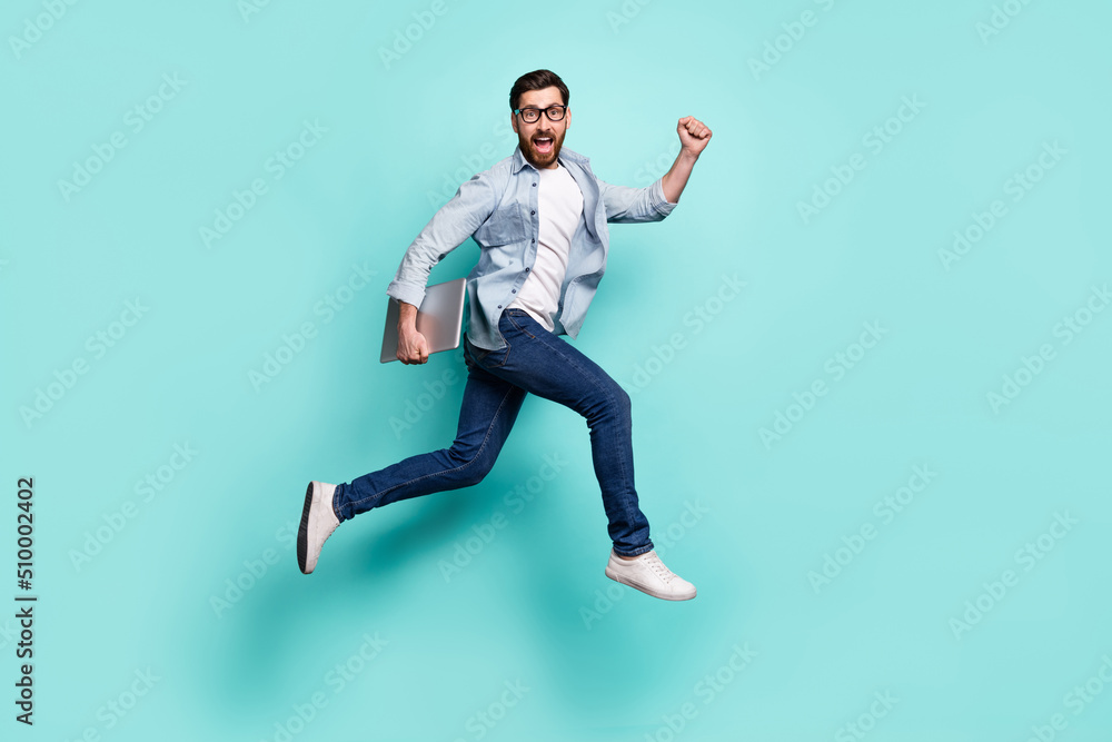 Full body photo of delighted overjoyed man hurry running jump isolated on teal color background