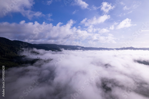 Aerial view of flowing fog waves on mountain tropical rainforest Bird eye view image over the clouds Amazing nature background with clouds and mountain peaks in Thailand