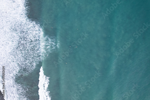 Amazing aerial view Top down of waves break on tropical sea Surfers with surfing boards Aerial drone view of sea waves on the beautiful ocean at Phuket Thailand