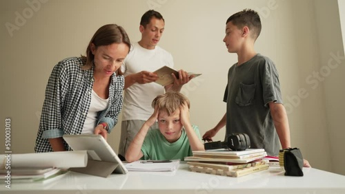 Father helping his son with schoolwork. Young little shoolboy solving mathematics homework with his family photo