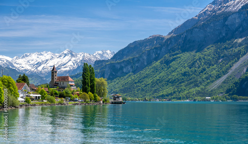 Obraz na płótnie church with snowy alps over Brienz lake in Switzerland w salonie