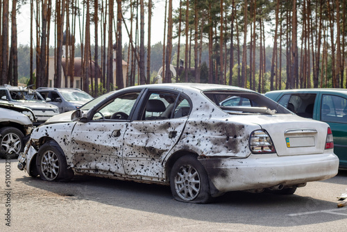 A car destroyed by shrapnel from a rocket that exploded nearby. Irpensky automobile cemetery. Consequences of the invasion of the Russian army in Ukraine. Destroyed civilian vehicle.