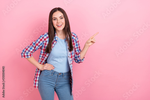 Photo of cheerful positive young girl point finger blank space promoting product isolated on pink color background © deagreez