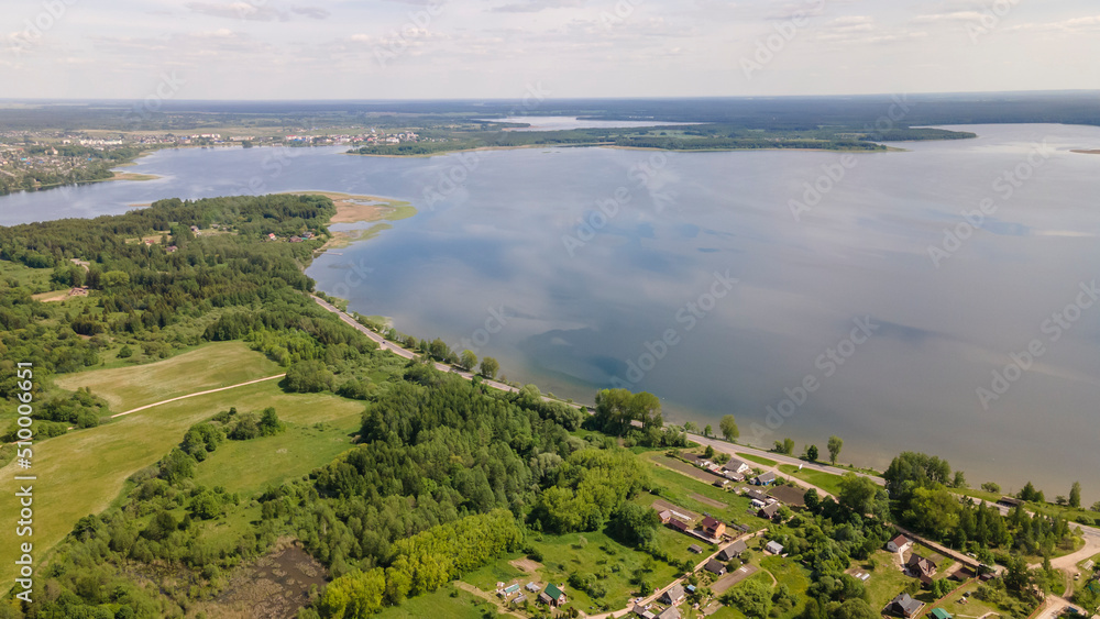 Obraz premium Aerial view of lake with sky reflection. Blue lake and green forest. Image for design. Space for text.
