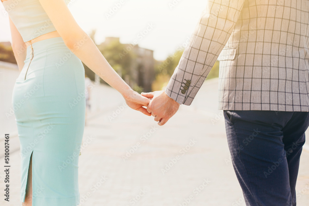 Loving couple holding hands together against the blue sky closeup. Loving couple holding hands together against the blue sky closeup.