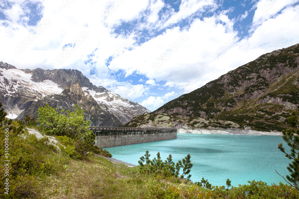 Alps mountains beautiful landscape with turquoise water lake. High mountains nature and view on dam of Gelmer lake reservoir, sunny summer day.