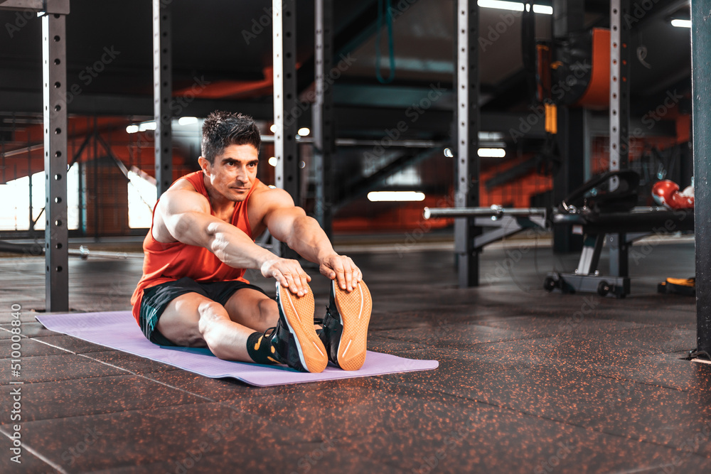 Portrait of a fitness man doing stretching exercises at gym. Portrait of a fitness man doing stretching exercises at gym.