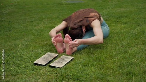 The woman stands on the nails. Close-up of human feet on sadhu board.