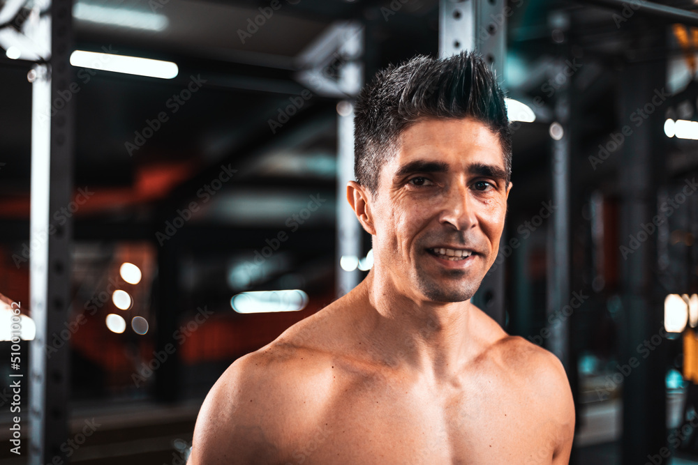 Portrait of a sweaty and muscular man smiling while looking in the room . Concept of: proper feeding, exercise, gym and fitness.. Portrait of a sweaty and muscular man smiling while looking in the room . Concept of: proper feeding, exercise, gym and fitness..