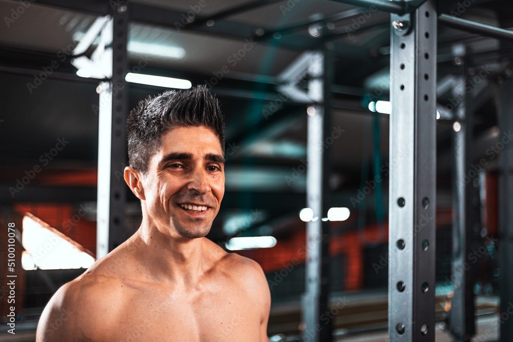Portrait of a sweaty and muscular man smiling while looking in the room . Concept of: proper feeding, exercise, gym and fitness.. Portrait of a sweaty and muscular man smiling while looking in the room . Concept of: proper feeding, exercise, gym and fitness..
