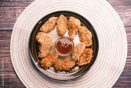 Crispy fried chicken wings on a plate top view .