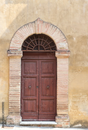 Old Wooden Door with Arch Brickwork and Ironwork in Perugia, Umbria, Italy © Monica