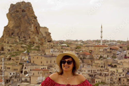 happy woman in a hat on the terrace in cappadocia, turkey 