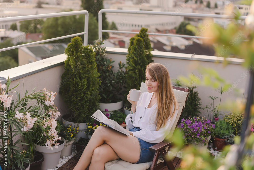 Woman with Coffee Reading Book on Rooftop Garden