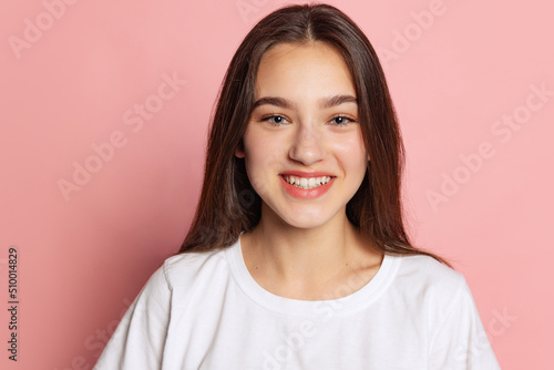 Wallpaper Mural Half-length portrait of young pretty girl in white t-shirt isolated on pink background. Concept of beauty, art, fashion, youth and emotions Torontodigital.ca