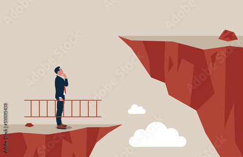 Confidence entrepreneur holding ladder about to climb cross to higher cliff. Solution to solve problem, motivation for business growth, improvement or brave to overcome difficulty or obstacle. photo