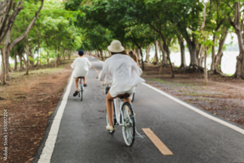 Blurred concept group of young woman ridding bicycle in the park.