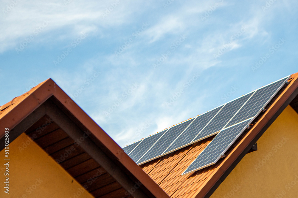 Fototapeta premium House roof with photovoltaic modules. Historic farm house with modern solar panels on roof and wall High quality photo