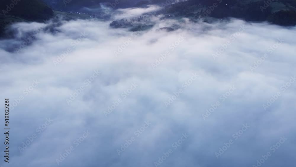 Aerial view of thick white clouds in a mountain forest valley above the trees. Top view of clouds. Aerial view of thick white clouds in a mountain forest valley above the trees. Top view of clouds.