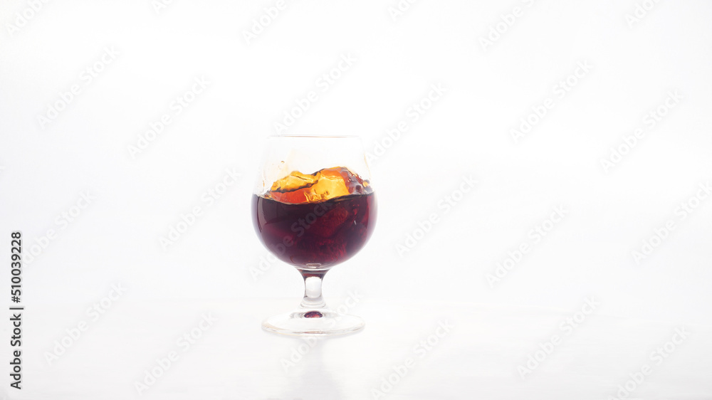 Red wine glass with ice making splash, on white background Red wine glass with ice making splash, on white background