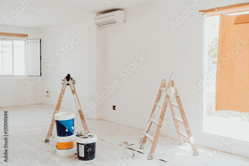 ladders and pots on white room at construction site. Painting walls. Home improvement, renovation