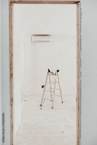 ladder on white room at construction site. Painting walls. Home improvement, renovation