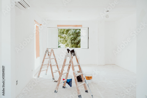 ladders and painter tools on white room at construction site. Painting walls. Home improvement, renovation