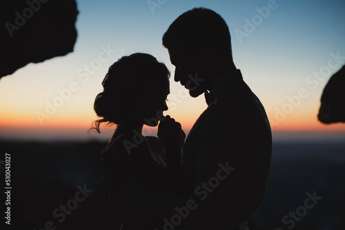 Foto Moonlight highlights the silhouettes of the bride and groom in the mountains