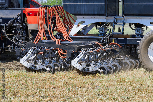 The tractor works in the field with an automatic seeder photo