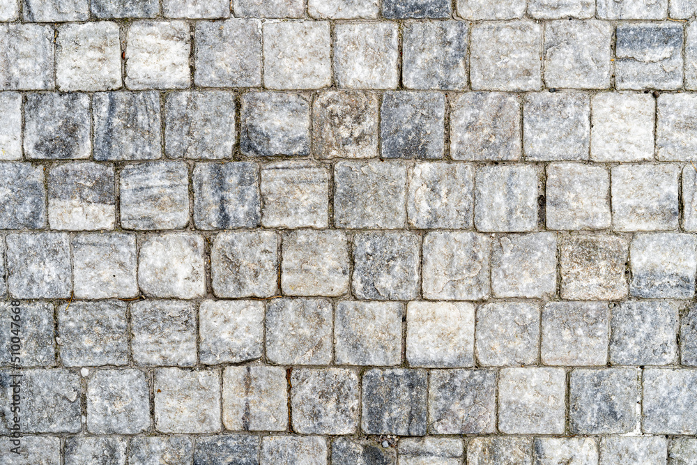 Granite cobblestone pavement, full frame of regular square cobbles in rows. Natural stone textured background Granite cobblestone pavement, full frame of regular square cobbles in rows. Natural stone textured background