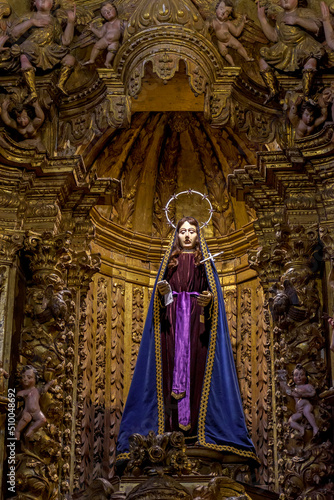 The crying saint. Sculpture in 18th century Brazilian Baroque sacred art surrounded by angels and present in the interior of the rich churches of Ouro Preto in Minas Gerais