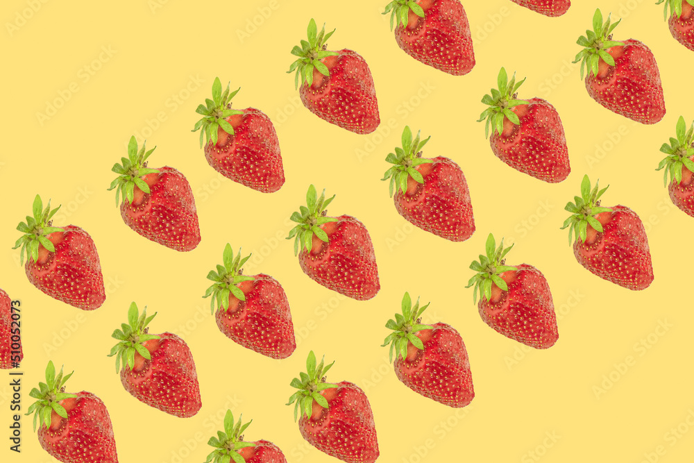 Raw strawberries in a diagonal rows on patel yellow background Raw strawberries in a diagonal rows on patel yellow background