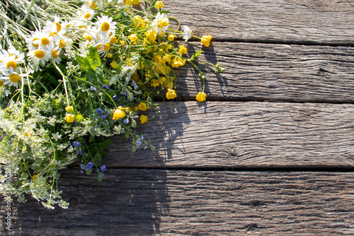 Summer bouquet of wildflowers on old wooden board background. Midsummer flowers. Top view  copy space 