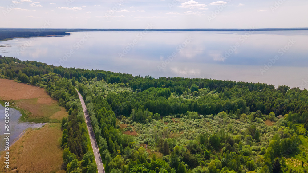 Aerial view of lake with sky reflection. Blue lake and green forest. Image for design. Space for text. Aerial view of lake with sky reflection. Blue lake and green forest. Image for design. Space for text.