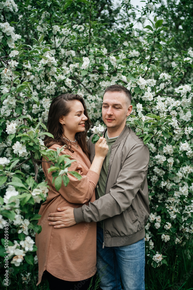 young couple in love girl and man hugging blooming apple tree aroma of flowers outdoors young couple in love girl and man hugging blooming apple tree aroma of flowers outdoors