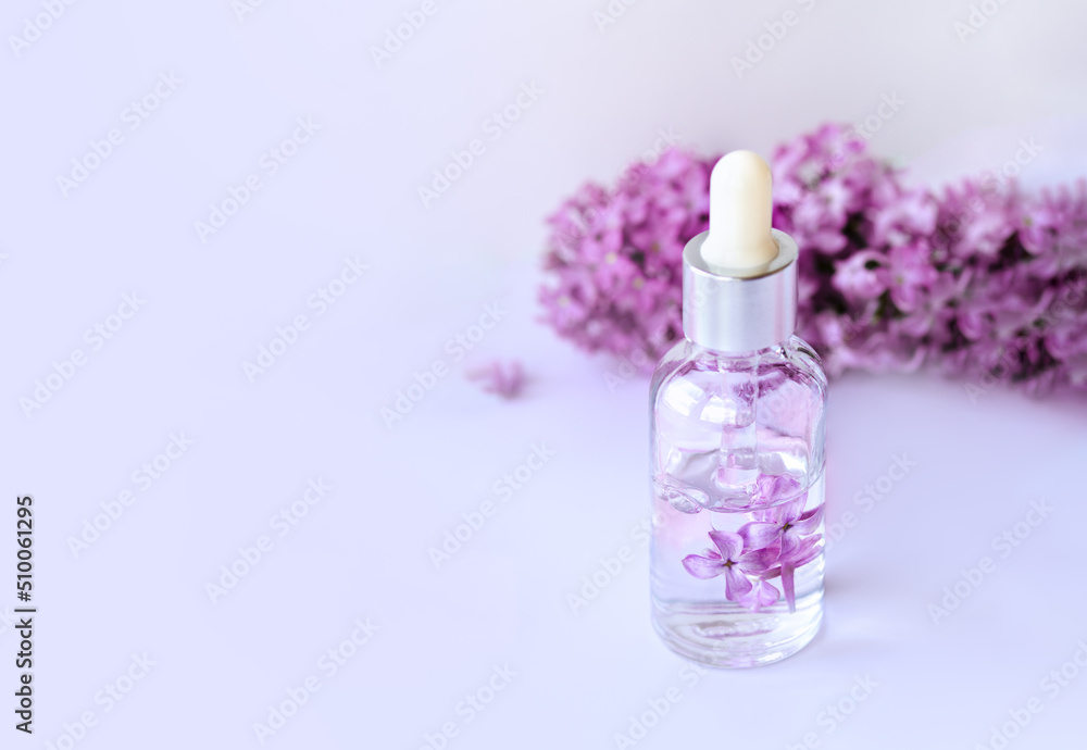 Closeup of glass dropper bottle with pipette with serum and lilac flowers. Essential oil, natural beauty cosmetics, bio science and research, skin care concept. Macro. Front view, high angle shot Closeup of glass dropper bottle with pipette with serum and lilac flowers. Essential oil, natural beauty cosmetics, bio science and research, skin care concept. Macro. Front view, high angle shot