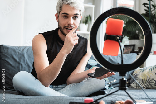 Transgender influencer streaming online makeup video tutorial on social media at home - Lgbt, gay, gender fluid concept photo