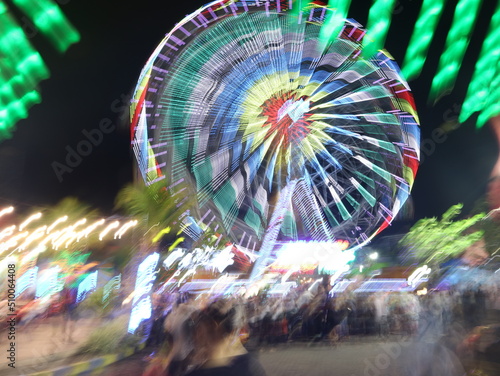 Blurry Ferris wheel with colorful lights. Bokeh lights. Party lights, out of focus, noise.