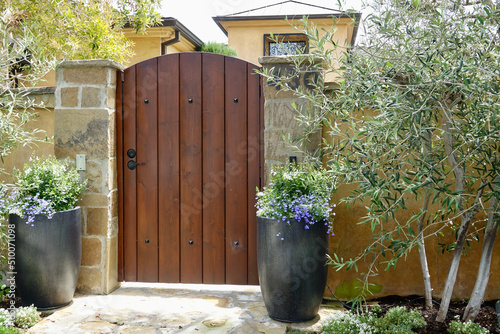 villa themed wood gate with stone pillars