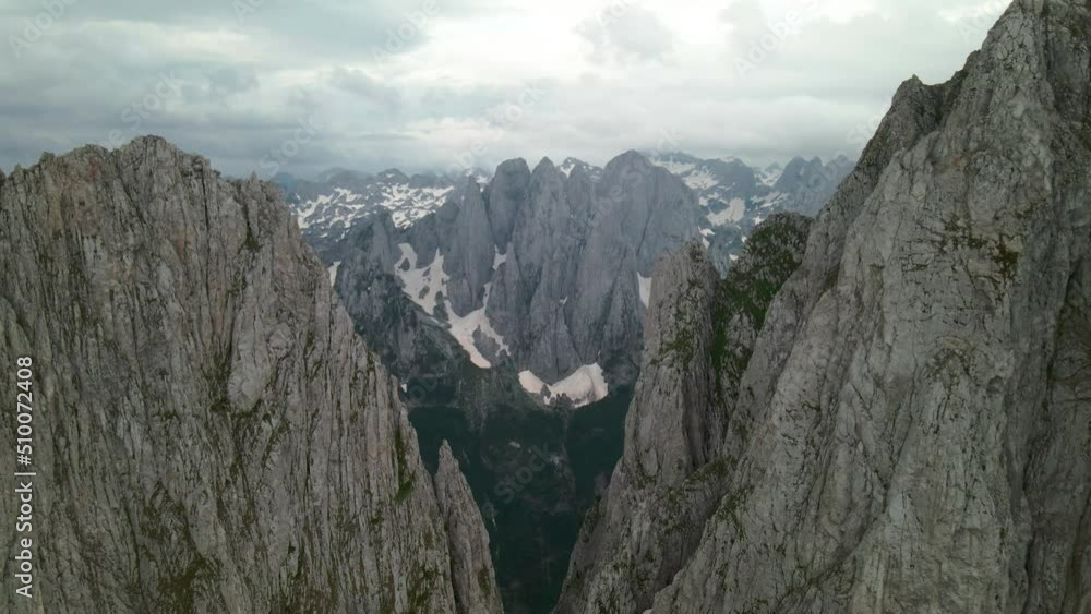 Flying between tall mountain walls towards valley of Albanian Alps. Aerial view of exposed terrain Flying between tall mountain walls towards valley of Albanian Alps. Aerial view of exposed terrain