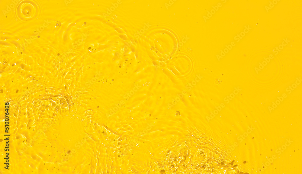Abstract summer background. Transparent yellow clear water surface texture with ripples, splashes and bubbles. Top view Abstract summer background. Transparent yellow clear water surface texture with ripples, splashes and bubbles. Top view