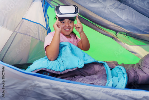 Girl with virtual reality headset, playing in a tent with a green background