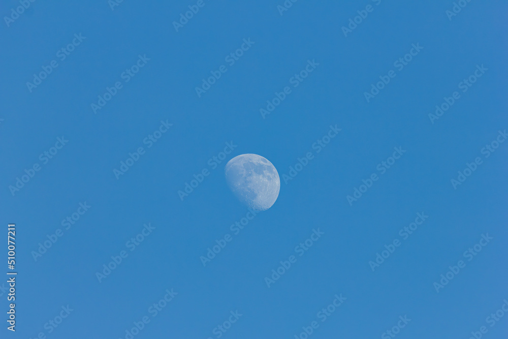 Bright moon on a blue sky background on a sunny day close-up Bright moon on a blue sky background on a sunny day close-up