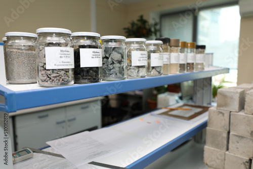 Modern laboratory for testing road samples and materials concept. Samples of bulk inert materials on laboratory shelves.
