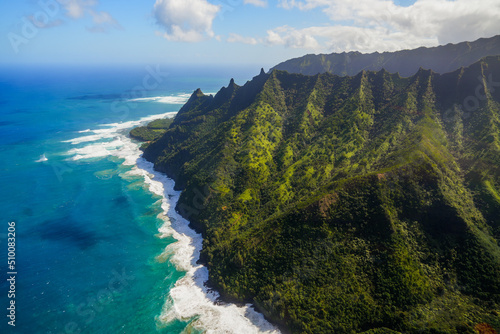 Aerial view of the dramatic ridges of the Na Pali coast, looming over the Pacific Ocean on the northwestern side of Kauai island in Hawaii