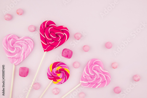 фотографія Pink candy lollipops and marshmallows are scattered